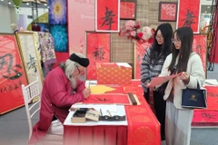 Young people seek calligraphy for good fortune during a fair in Hanoi. (Photo: VNA)
