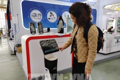 A visitor experience the robot receptionist at the Spring Fair 2026. (Photo: VNA)