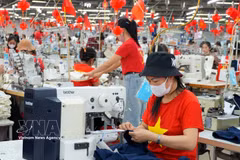 Workers manufacture garments for export. (Photo: VNA)