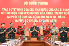 Deputy Chief of the General Staff of the VPA Senior Lieutenant General Phung Si Tan (centre) hands over the President’s decisions to the officers undertaking UN peacekeeping missions at the ceremony. (Photo: VNA) 