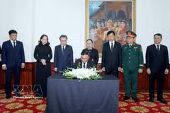 Politburo member and Standing member of the Communist Party of Vietnam (CPV) Central Committee’s Secretariat Tran Cam Tu signs the condolence book in commemoration of Politburo member of the Lao People's Revolutionary Party (LPRP) and President of the Lao NA Xaysomphone Phomvihane. (Photo: VNA)