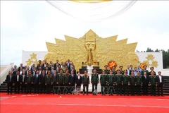 Delegates pose for a group photo at the Vietnam-Laos combat alliance monument in the southern Lao province of Champasak on July 1. (Photo: VNA)
