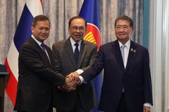 Malaysia's PM Anwar Ibrahim (centre), Cambodia's PM Hun Manet (left) and Thailand's acting PM Phumtham Wechayachai shake hands following a press conference in Malaysia on July 28. (Photo: XINHUA/VNA)