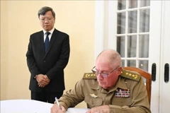 Minister of the Cuban Ministry of the Revolutionary Armed Forces Senior Lieutenant General Alvaro Lopez Miera writes in the condolence book at the Vietnamese Embassy in Cuba. (Photo: VNA)