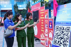 Young voters in Ho Chi Minh City scan an QR code to participate in an online quiz about the Election Law. (Photo: VNA)
