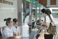 Patients register at the reception desk upon arrival for medical examination. (Photo: VNA)