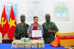 The trafficker (R) caught red-handed transporting drugs from Cambodia. (Photo: VNA)