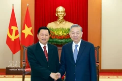 Party General Secretary To Lam (right) receives Lao Minister of Public Security Vanthong Kongmany in Hanoi on March 20. (Photo: VNA)
