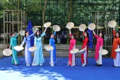 The soulful music set the stage for Vietnamese graceful women in flowing ao dai and tilted conical hats, moving with elegance. (Photo: VNA)