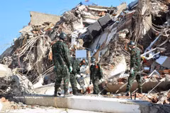 Vietnamese rescuers work to reach trapped victims under rubble. (Photo: VNA)