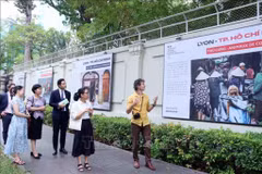 Adrien Jean (right) introduces his photos at the exhibition (Photo: VNA)