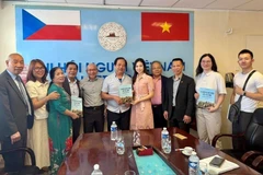 Nguyen Quyet Tien (sixth from left), an engineer and translator, donates a set of Vietnamese-Czech-English dictionaries to the Vietnamese language centre. (Photo: VNA)