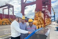 Workers install and operate a ship docking monitoring system at Chu Lai Port. (Photo: VNA)