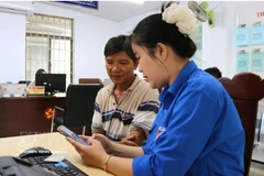 Young people introduce and guide local residents in Ha Tinh province on how to use the "i-HaTinh" digital citizen application. (Photo: VNA)