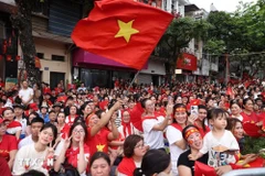 People happily welcome the forces joining in a rehearsal for the National Day parade. (Photo: VNA)