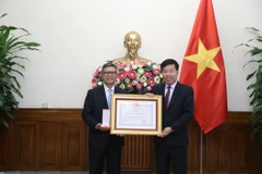 Deputy Foreign Minister Nguyen Manh Cuong (R), on behalf of the State President, presents the Friendship Order to Indonesian Ambassador to Vietnam Denny Abdi at a ceremony in Hanoi on October 31 (Photo: VNA)