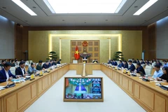 Prime Minister Pham Minh Chinh (centre) chairs a hybrid meeting meeting with ministries, central agencies and local authorities on December 17 to review the implementation of the “Quang Trung Campaign” to rebuild and repair homes that are severely damaged by recent storms and floods. (Photo: VNA)