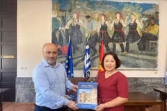 Deputy Mayor of Rhodes in charge of economy, finance, and cultural heritage Chalkias Konstantinos (L) presents a book to Vietnamese Ambassador to Greece Pham Thi Thu Huong. (Photo: Published by VNA)