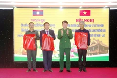 The Quang Tri Border Guard Command presents gifts to delegates from Savannakhet and Khammouane provinces of Laos, as well as Quang Tri province, at the conference in Dong Hoi ward. (Photo: VNA)