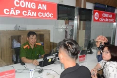 A police officer help residents change citizen identity cards at the public service centre of the newly formed Hon Gai ward, Quang Ninh province. (Photo: VNA)
