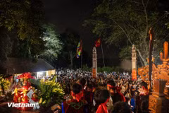 The procession returning Saint Tan Vien’s palanquin to Tuong Phieu communal house features a unique nighttime ritual that attracted thousands of participants. Four giant torches up to 13 metres high were lit during the ceremony. (Photo: VietnamPlus)