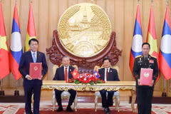 Vietnamese Party General Secretary To Lam (second, left), and Party General Secretary and President of Laos Thongloun Sisoulith witness the exchange of memorandum of understanding (MoU) on cooperation between the Vietnamese Ministry of Public Security and the Lao Ministry of National Defence on building a Vietnam - Laos friendship road. (Photo: VNA)
