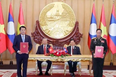 Vietnamese Party General Secretary To Lam (second, left), and Party General Secretary and President of Laos Thongloun Sisoulith witness the exchange of memorandum of understanding (MoU) on cooperation between the Vietnamese Ministry of Public Security and the Lao Ministry of National Defence on building a Vietnam - Laos friendship road. (Photo: VNA)