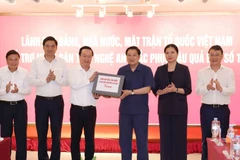 Politburo member Phan Dinh Trac hands over assistance from Party, State and Vietnam Fatherland Front leaders to people of the central province of Nghe An (Photo: VNA)