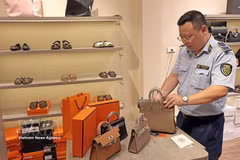 An officer of the market surveillance unit No. 2 inspects a retail outlet on Hang Dao street, Hanoi, in 2025. (Photo: VNA) 