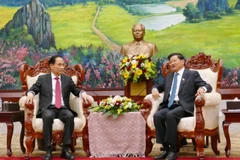 Minister of Foreign Affairs Le Hoai Trung (L), who is Special Envoy of General Secretary of the Communist Party of Vietnam (CPV) Central Committee To Lam, meets with General Secretary of the LPRP Central Committee and President of Laos Thongloun Sisoulith. (Photo: VNA)