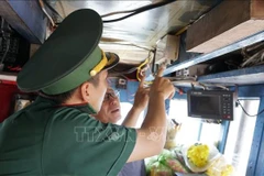 A border guard officer in Gia Lai inspects the vessel monitoring system before allowing a fishing boat to depart. (Photo: VNA)