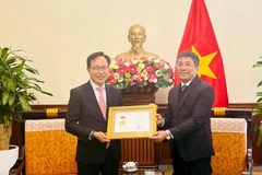 Permanent Deputy Minister of Foreign Affairs Nguyen Minh Vu (right) awards the For the Cause of Vietnam’s Foreign Affairs insignia to General Director of Samsung Vietnam Choi Joo Ho on February 13. (Photo: VNA)