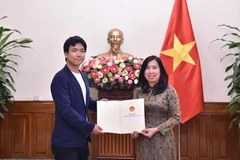 Deputy Minister of Foreign Affairs Le Thi Thu Hang hands over a licence allowing Japan's TV news agency Nihon Denpa News to reopen its resident office in Vietnam (Photo: baoquocte.vn)