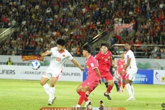 A Vietnamese national team player handles the ball in Laos’s penalty area. (Photo: VNA)