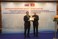 Prof. Academician Chau Van Minh (L), President of the Vietnam Academy of Science and Technology (VAST), is awarded the title of “Ambassador of Russian Education and Science” at a ceremony co-organised by the Russian Embassy in Vietnam and the academy, in Hanoi on February 5 (Photo: VNA)