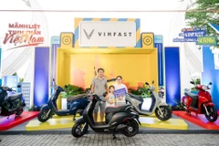 A rider exchanges his fossil fuel-powered motorbike for an electrical one at an event held by Vinfast in Hanoi. (Photo: VNA)