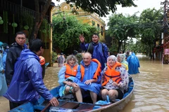 Rescuers assist foreign tourists in moving to a safer place in Da Nang on October 28, 2025. (Photo: VNA)