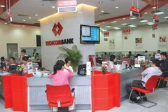 Customers make transactions at a Techcombank’s office in Hanoi. (Photo cafef.vn)