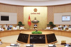 Prime Minister Pham Minh Chinh chairs the Government meeting in Hanoi on October 1 to review the implementation and address challenges related to the two-tier local administration model. (Photo: VNA)