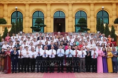State President Luong Cuong (front, tenth from left) and standout artisans pose for a group photo at the meeting in Hanoi on June 10. (Photo: VNA)