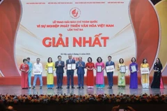 Deputy Prime Minister Mai Van Chinh and Minister of Culture, Sports and Tourism Nguyen Van Hung present first prizes to the winners. (Photo: VNA)