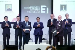 The signing ceremony is witnessed by Prime Minister Pham Minh Chinh. (Photo: VNA)