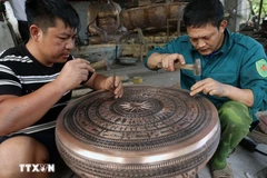 Completing a bronze drum at the workshop of artisan Dang Quoc Toan in Tra Dong bronze-casting village. (Photo: VNA)