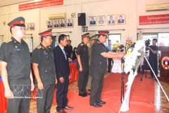 Representatives of the armed forces of southern Lao provinces offer flowers at the ceremony. (Photo: VNA)