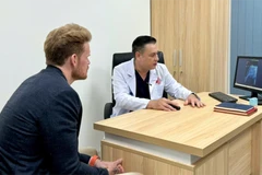 D.F (left), a US patient, at a follow-up examination with Do Lenh Hung, head of the department of urethral reconstructive surgery. (Photo: VNA)