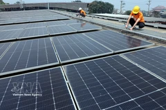 Workers installs solar power panels. In Vietnam, green growth and sustainable development have been identified as overarching strategies in socio-economic development. (Photo: VNA)