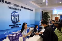 Civil servants at the Hanoi Public Administrative Service Centre assist residents with administrative procedures. (Photo: VNA)