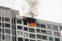 Smoke and flames rise from an apartment building in Ho Chi Minh City in late 2025. (Photo: VNA)