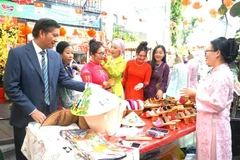 Vietnamese Ambassador to Malaysia Dinh Ngoc Linh (L) visits a booth at the event (Phôt: VNA)