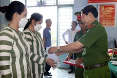 A police officer hands over amnesty decisions to prisoners in Soc Trang province (Photo: VNA)
